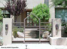 Modern home with a metal gate as you head to the front door. Love the metal wall sconces as well. #gates #metalgate