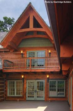 Lodge with a large second-story balcony, a courtyard in back, wood shake shingles for the siding and a dark wood deck. Click on the image to see how to go green with your home siding. #lodge #rustic