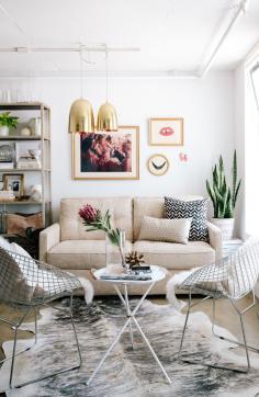 modern chic living room with sheepskin chairs and gold light pendants.