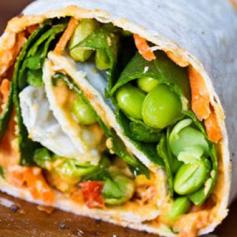 Veggie wrap!  Roasted red pepper hummus, shredded carrots, baby spinach, splash of lemon juice/olive oil, fresh ground pepper, edamame & avocado slices