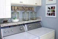 Small laundry room with a fun custom shelf and great way to display laundry detergents.