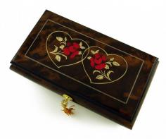 A definite must have gift for that romantic occasion. Give someone special a keepsake that will be cherished forever. This stunning musical jewelry box is hand crafted in Sorrento, Italy and uses only the finest quality material available and is constructed of solid burl-walnut and rosewood. This lovely music jewelry box features a theme of love and the bond between people in a artistic expression of two vibrant red roses centered in a heart outline. The use of cream and red wine stains are complimented by the amazing warm wood tune stain that encompasses the entire music box. Inside you'll find a plenty of space for your previous jewelry and keepsakes. You'll also find a dedicated compartment which houses a traditional mechanical movement that omits a harmonious tune when the lid is opened. The music box incorporates a fully functional lock and key and matching gold hardware throughout the box. This item can be fitted with higher note options. Please refer to the individual item listing for pricing. With over 380+ tunes available, your sure to find that perfect melody. Please see "item options" for available tunes or visit our "listening station" for all song titles as well as sample clips. Thank you very much for your interest in our products! Your satisfaction is always guaranteed at the Attic! Dimensions: Length - 10.5" Width - 6" Depth (Height) - 2.75