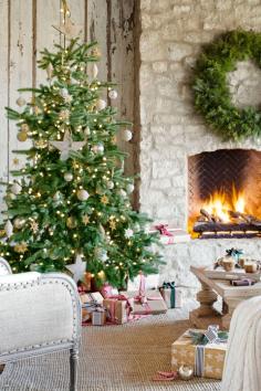 A stone fireplace keeps an elegant Christmas tree toasty on the covered patio of this Arizona home, furnished like a full-fledged living roo...