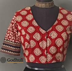 An Ajrakh Dabu Gamthi blouse is a traditional Indian garment that combines three distinct artisanal techniques: Ajrakh, a centuries-old block-printing method known for its intricate geometric and floral patterns in rich colors like indigo and red; Dabu, a mud-resist hand-block printing technique creating beautiful contrasts through a unique resist-dye process; and Gamthi, featuring traditional rural or ethnic prints. This blouse showcases the rich textile heritage of India, blending detailed patterns and vibrant colors to create a unique, handcrafted piece that highlights skilled craftsmanship and cultural tradition.