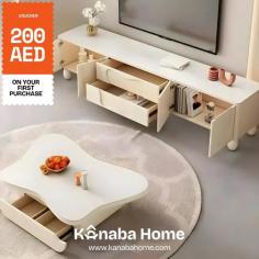 White coffee table with two drawers in front of a white entertainment center. The coffee table has a simple, modern design with clean lines and a smooth surface. 

Visit:- https://kanabahome.com/
