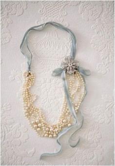 For this classy necklace, fold a long pearl necklace in half and tie ribbon around each side. Add a broach by the bow for some extra sass.