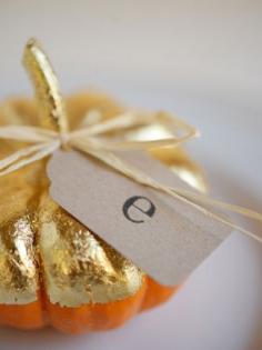 These mini pumpkins are half painted in gold paint -- use them as a place card setting for an elegant way to decorate a dinner party