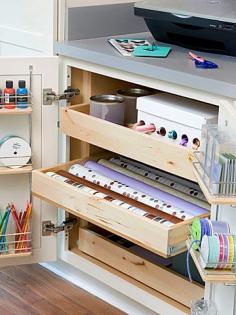 Crafts Cabinet Hideaway- One cabinet in a home office can hide crafts supplies but keep them within reach. These pullout drawers are perfect for holding wrapping paper, ribbon, and tins of other supplies. Use the inside door space too, perfect for housing paint jars, vases filled with color pencils, and more ribbon. The counter holds a copier for enlarging patterns.