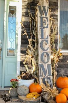 Fall Front Porchwith a large rustic welcome sign, cornstalks, pumpkins, and pine cones