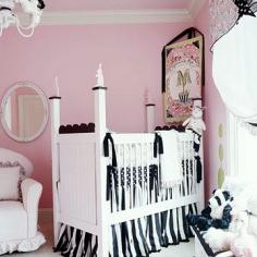 This nursery is girly and bold with a pink, black, and white color palette. The pink walls and ruffled window treatments show that this room is meant for a baby. But the oversize rocker, antique mirror, and classic white furniture will make this scheme easy to convert to a tween or guest room.