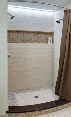 The master bath shower has two showerheads, and a long horizontal niche for plenty storage