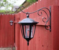 Dollar store solar lights on plant hook - LOVE this idea. Back yard