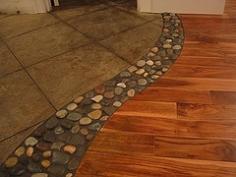 River rock in between wood and tile floors.  Love this creative idea for the transition between types of flooring.