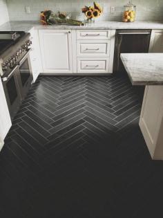 herringbone tile floor, Dark tile with lighter grout.  White cabinets and translucent glass backsplash lighten the mood.  Modern take on classic herringbone pattern.