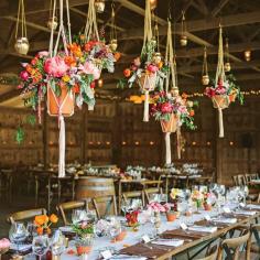Macramé hanging floral arrangements work wonders for this barn wedding reception.