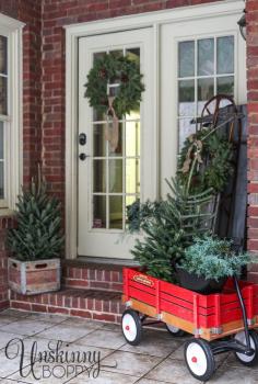 Pretty back porch decorated for Christmas with vintage Radio Flyer wagon and an old sled.