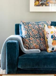 Gorgeous blue velvet couch with complimenting patterned pillows