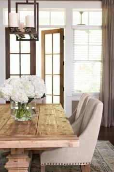 Beautifully designed dining room! Notice the unique candle chandelier and rustic wooden table.