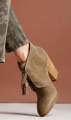 Soft suede lace up bootie with tassel detail on laces, rounded toe and a stacked heel.