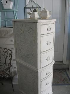 Salvaged dressing table drawers were covered with tin ceiling tiles, stacked & painted.