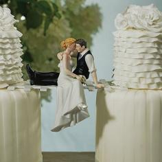 Create a stunning wedding cake with this 'The Look of Love' bride and groom cake topper. Caught sneaking a kiss, this laid-back couple takes a moment for romance. Place the groom on top of a layer of the wedding cake and let him embrace his bride and she dangles her legs over the edge or create a fun and unique bridge as we show in the photo