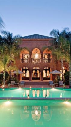 Lantern-lit gardens & a palm tree–lined pool in #Morocco.