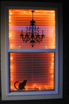 I love this Halloween window decor idea, with orange lights and black silhouettes -- it's classy and simple. (She used a chandelier decal from Target and a black cat silhouette from Martha Stewart.)