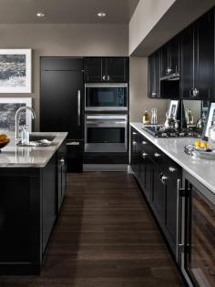 The refrigerator is cleverly concealed behind a cabinetry panel, and a dual-zone wine storage cabinet offers space for up to 46 bottles. Stainless steel accents and cherry wood-faced shelves complement the kitchen's design aesthetic.