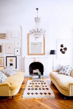 Why It Works: Double Sofas // yellow sofa, fireplace, crystal chandelier, gallery wall