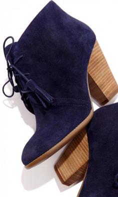 Soft suede lace up bootie with tassel detail on laces, rounded toe and a stacked heel.