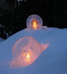 Fill a round balloon with water and set outside until almost frozen through. Run hot water over frozen globe until balloon pops off. Pour out unfrozen water from inside and insert a tealite. Makes a great walkway accent. These are gorgeous.