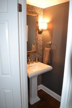 wall of tile in 1/2 bath- like to do this in main floor bath. Floor to ceiling tile on the wall with sink and toilet