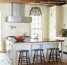 Rustic and traditional kitchen with a unique chandelier, a large island with a wood top, three barstools and a sleek range hood. See what they spent on the remodel. #kitchenreno #rustic