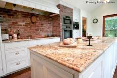 Traditional kitchen with a brick backsplash, a large granite island, double ovens, white walls and a french country vibe. Would you go with brick?