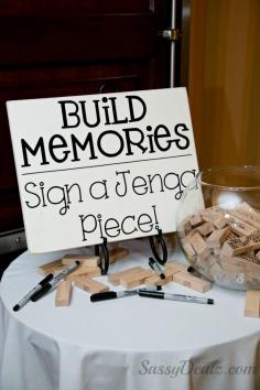 DIY Jenga guestbook wedding idea! The sign "Build memories sign a jenga piece" was made from a wood board with decal letters. Just buy the jenga game and spread the wood pieces out on the table. Buy 5-7 thin point black sharpies so your guests can write on them. Buy a big fish bowl for them to put the jenga blocks in when they were done. Lots of compliments!