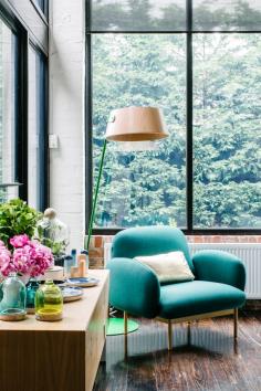 
                        
                            Living room with turquoise chair and a green view
                        
                    