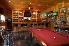 Recreate your favorite bar with this #mancave design. A massive bar area paired with an equal sized pool table is a sure way to have your friends coming back for more fun. #woodpaneling #pictureframes
