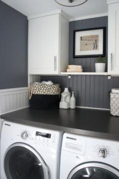 
                    
                        Bead board, grey walls, large tabletop and plenty of storage in laundry room
                    
                