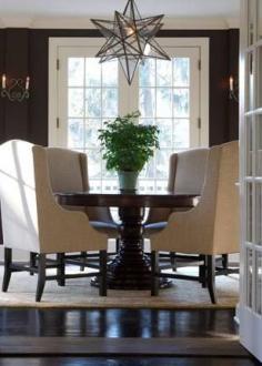 
                    
                        WIngback chairs at the dining table and a geometric chandelier
                    
                