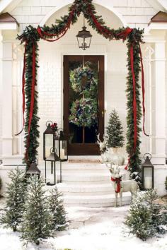 
                    
                        This gorgeous outdoor holiday display features rope garland, red ribbon, lanterns, and a few reindeer for an unexpected surprise!
                    
                