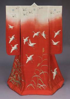 
                    
                        Outer robe (uchikake), late 19th century, Japan,  with long sleeves and padded hem and design of flying cranes (tsuru) and autumn grass (susuki) embroidered, printed and handpainted in white, gray, black, green and brown on a predominantly red ground with white across the shoulders suggesting sunset (akebono); five chrysanthemum crests on center back and shoulders and front shoulders. Silk plain-weave crepe (kabe-chirimen); hand drawn paste resist-dyed and painted (yûzen), embroidered
                    
                