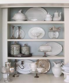 
                    
                        Using ironstone, silver and glass objects to decorate a bookcase instead of books.  From Vintage American Home.
                    
                