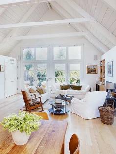 white living room with a high peaked ceiling. I love the windows.