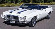 
                    
                        The 1969 Pontiac Trans Am started with a Firebird and added a functional twin-scoop hood, rear spoiler, open fender vents and a unique white and blue paint scheme. Under the hood was a 335-bhp, 400-cid, V-8 engine with a standard Ram Air induction system.
                    
                
