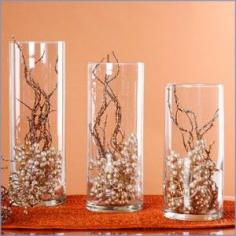 
                    
                        These lovely glass vases filled with pearls and branches make inexpensive centerpieces.
                    
                