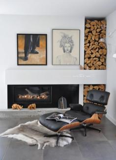 Lounging in luxury: Eames chair, hide rug, fireplace, built in wood storage and artwork. The perfect reading corner