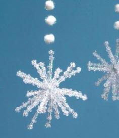 
                    
                        Snowflake decorations made with 6 pipe cleaners cut in half to make 12 pieces.  Use one piece to wrap tightly around the others and splay all the ends to make a snowflake shape.  Put about 5 clear beads onto each strand and thread pompoms onto fishing wire or thread to hang.
                    
                