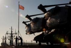 
                    
                        U.S. sailors raise the ship’s colors as the USS Iwo Jima pulls into port.
                    
                