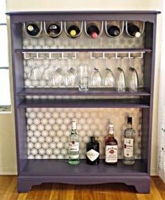 
                    
                        Find an inexpensive bookshelf at your local Goodwill and paint it any color you like and then if you like add a fun background with wrapping paper or scrapbook paper if you want a more fun look. Just add wine and glass hooks to hang your bottles and glasses! It's that easy and it makes for a great entertaining space!
                    
                