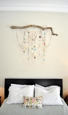 
                    
                        wall hanging made from strands of beads, seashells and chandelier prisms, hanging from a driftwood branch.
                    
                